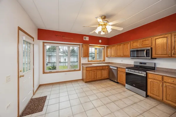 a large kitchen with a large window cabinets and stainless steel appliances