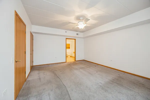 an empty room with a ceiling fan and a window
