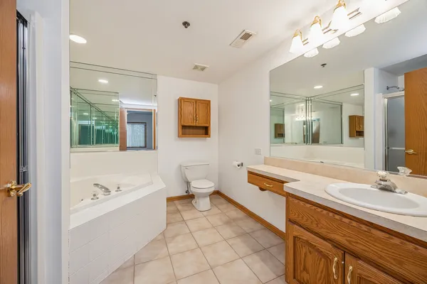 a spacious bathroom with a double vanity sink a mirror and a bathtub