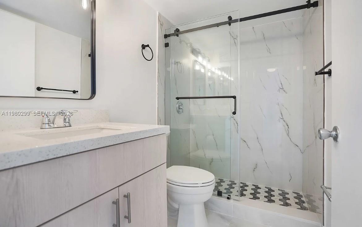 8260 Southwest 210th Street, Unit 302 Cutler Bay, FL 33189 - Photo 14 of 42 a bathroom with a sink vanity granite toilet and shower