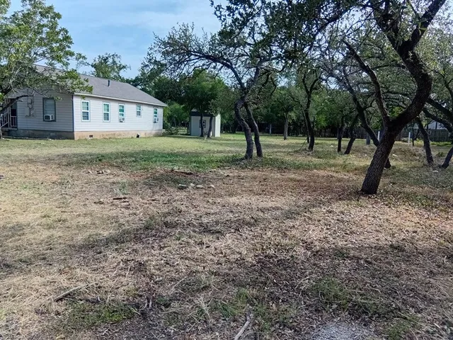 a view of house with a backyard
