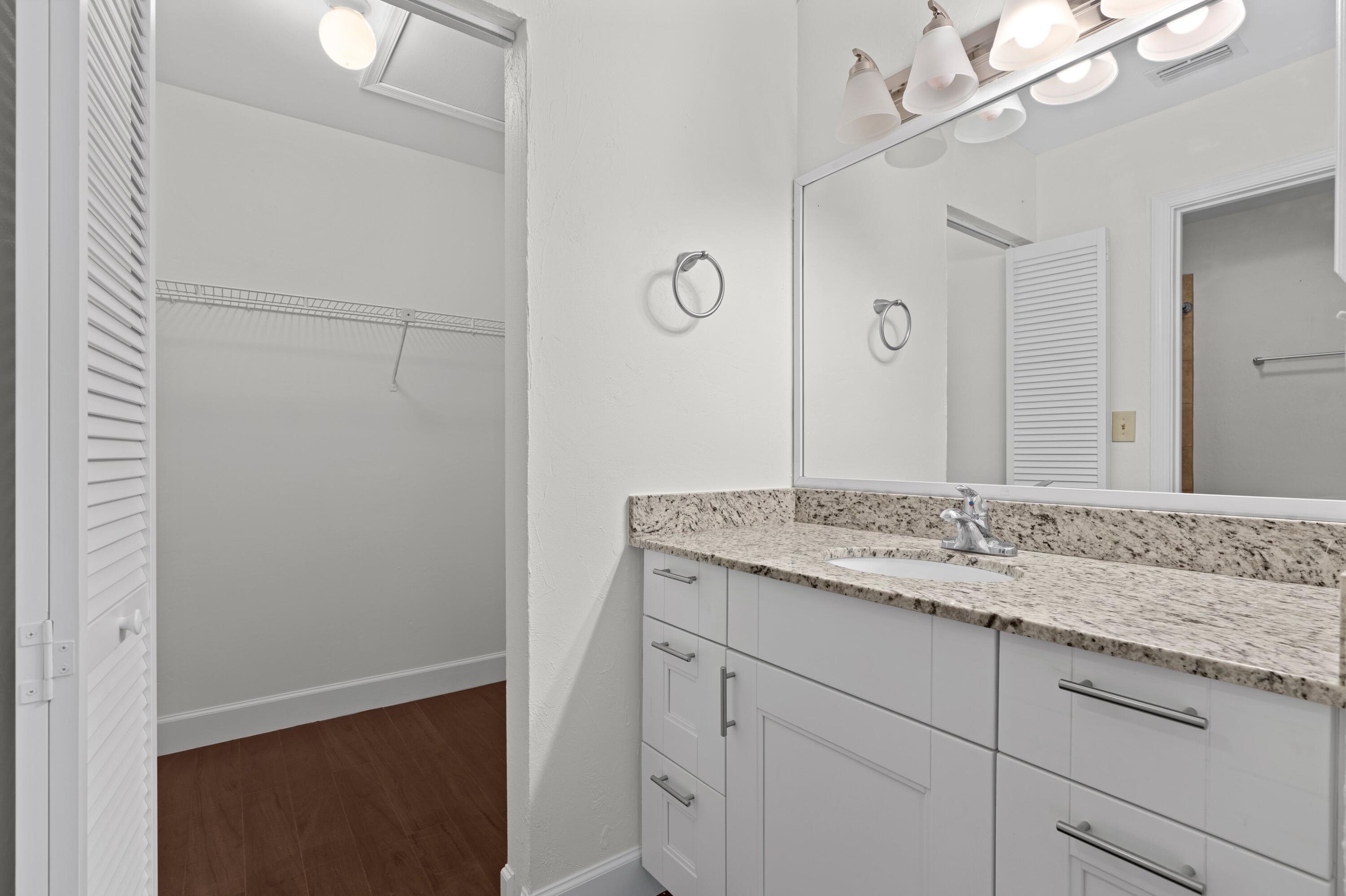 3139 Millwood Terrace, Unit M225 Boca Raton, FL 33431 - Photo 9 of 25 a bathroom with a granite countertop sink and a mirror