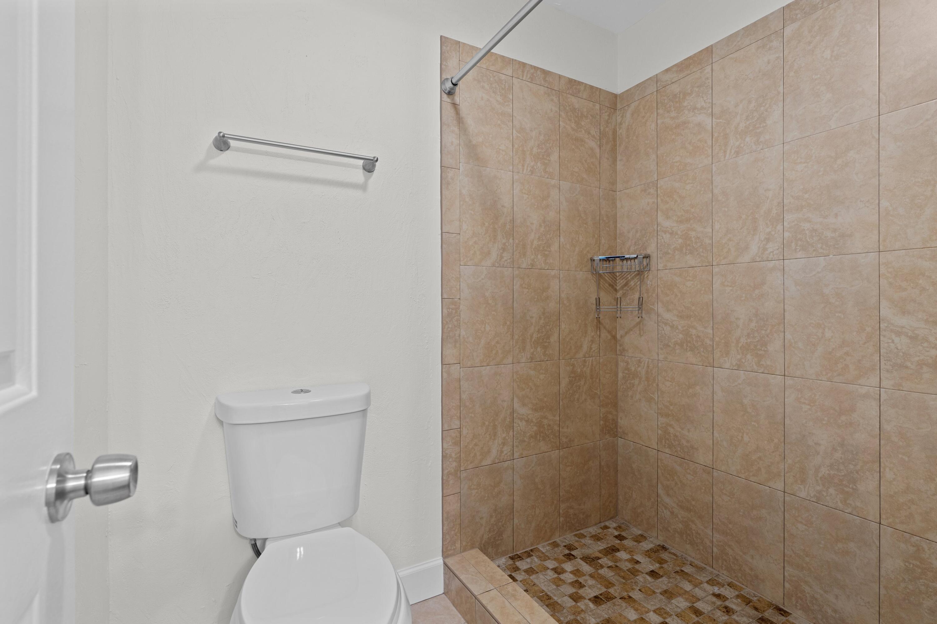 3139 Millwood Terrace, Unit M225 Boca Raton, FL 33431 - Photo 10 of 25 a bathroom with a toilet and a shower