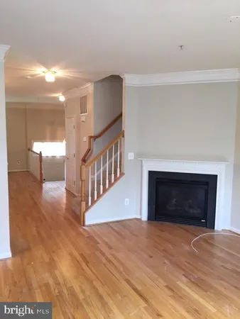a view of an empty room with fire place and a window