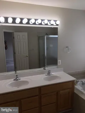 a bathroom with a double vanity sink and a mirror