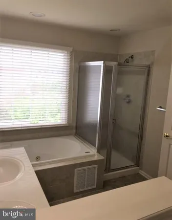 a bathroom with a tub sink and shower