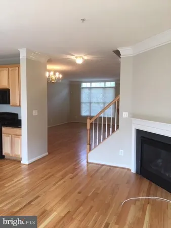 a view of a livingroom with wooden floor fireplace and staircase