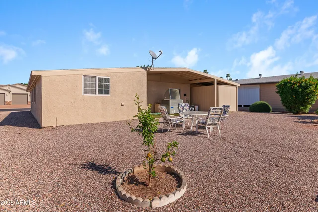 a view of a patio with table and chairs potted plants and floor to ceiling window