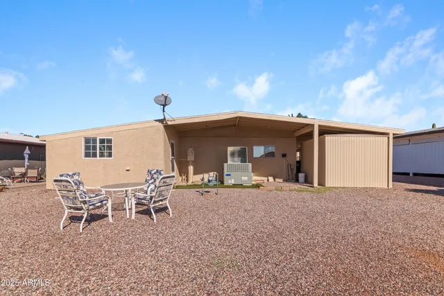 a view of a house with backyard and sitting area