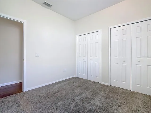 a bathroom with a granite countertop sink a toilet a mirror a bathtub and shower