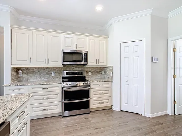 a kitchen with granite countertop a stove microwave and a sink with granite countertops