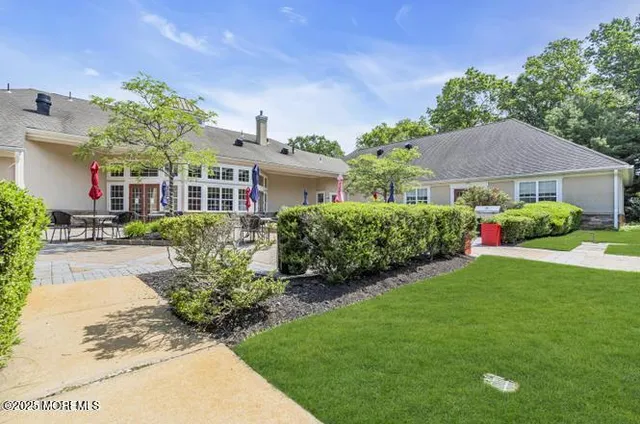 a front view of a house with sitting area and garden