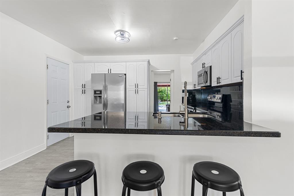 6375 Southwest 29th Street Miami, FL 33155 - Photo 12 of 51 a kitchen with stainless steel appliances granite countertop a sink a microwave a refrigerator and cabinets