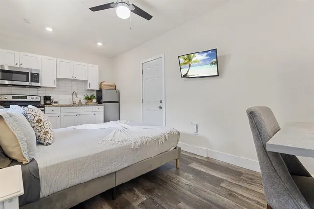 a spacious bedroom with a bed a couch and a chandelier