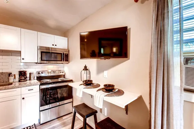 a kitchen with stainless steel appliances a stove microwave and a sink