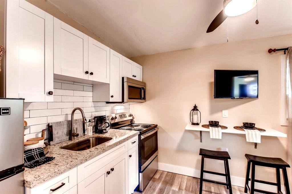 6375 Southwest 29th Street Miami, FL 33155 - Photo 36 of 51 a kitchen with stainless steel appliances a sink a stove and white cabinets with wooden floor
