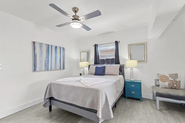 a bedroom with a bed chandelier and a window