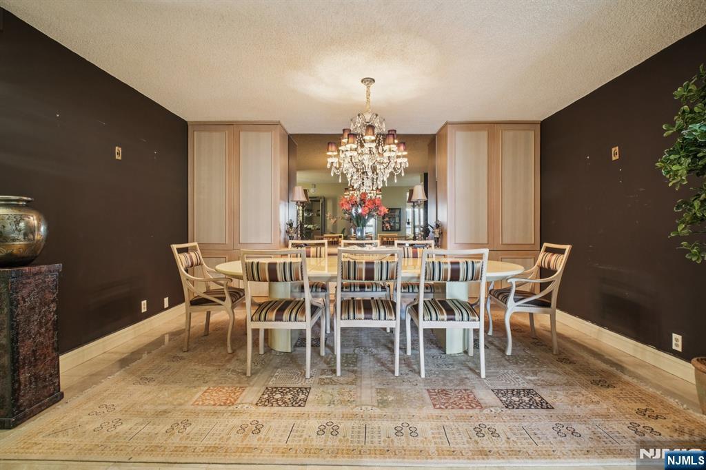 800 Palisade Avenue, Unit PH21A Fort Lee, NJ 07024 - Photo 11 of 50 a dining room with furniture a rug and a chandelier