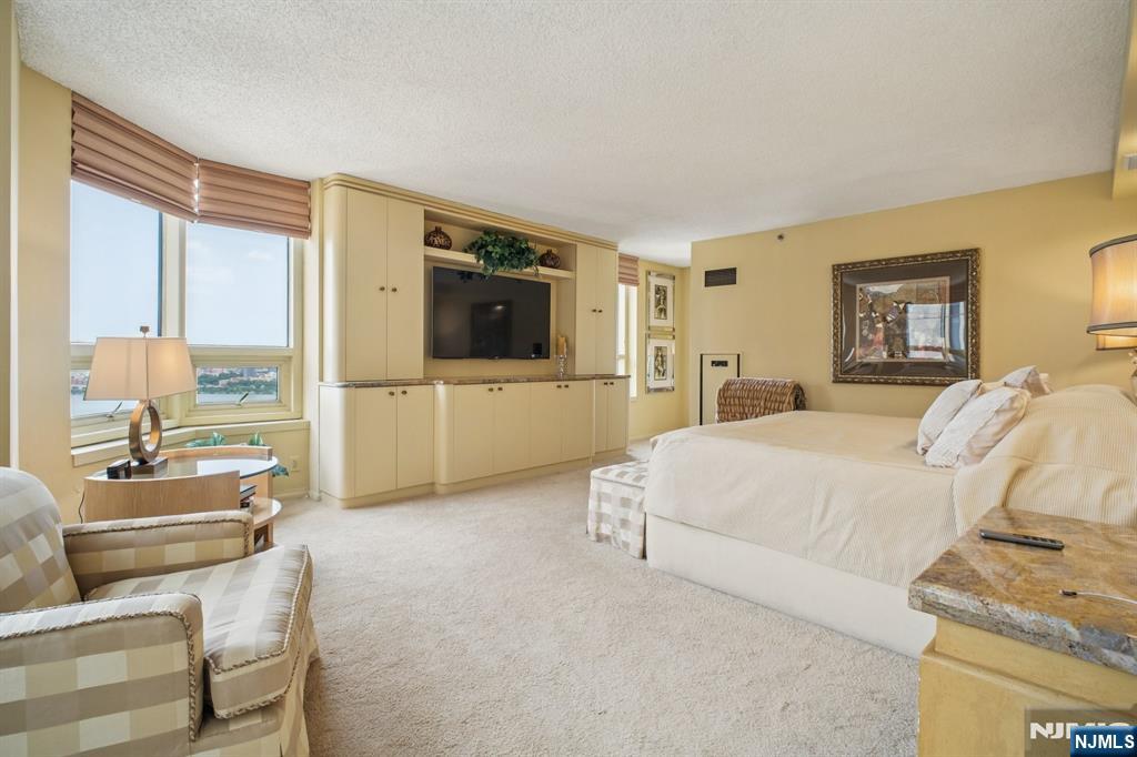 800 Palisade Avenue, Unit PH21A Fort Lee, NJ 07024 - Photo 18 of 50 a spacious bedroom with a bed and glass door