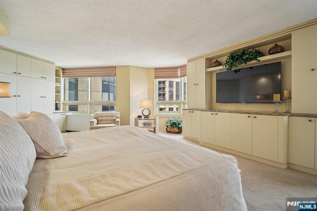 800 Palisade Avenue, Unit PH21A Fort Lee, NJ 07024 - Photo 21 of 50 a bedroom with a large bed and a flat screen tv