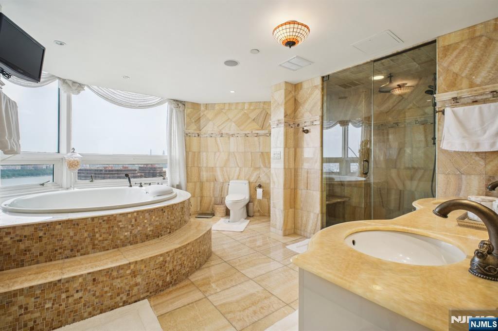 800 Palisade Avenue, Unit PH21A Fort Lee, NJ 07024 - Photo 24 of 50 a bathroom with a sink double vanity mirror and a bathtub