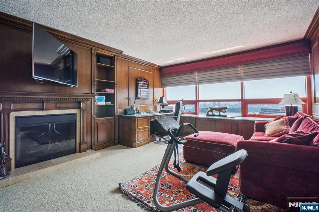 800 Palisade Avenue, Unit PH21A Fort Lee, NJ 07024 - Photo 31 of 50 a living room with furniture a flat screen tv and a fireplace