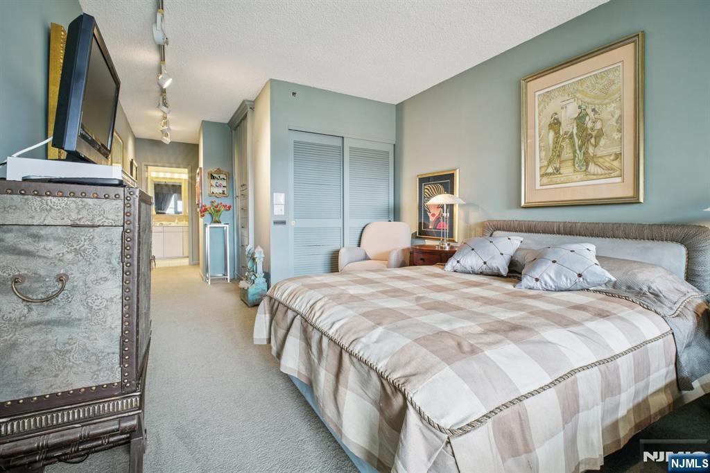 800 Palisade Avenue, Unit PH21A Fort Lee, NJ 07024 - Photo 33 of 50 a bedroom with bed and a flat screen tv