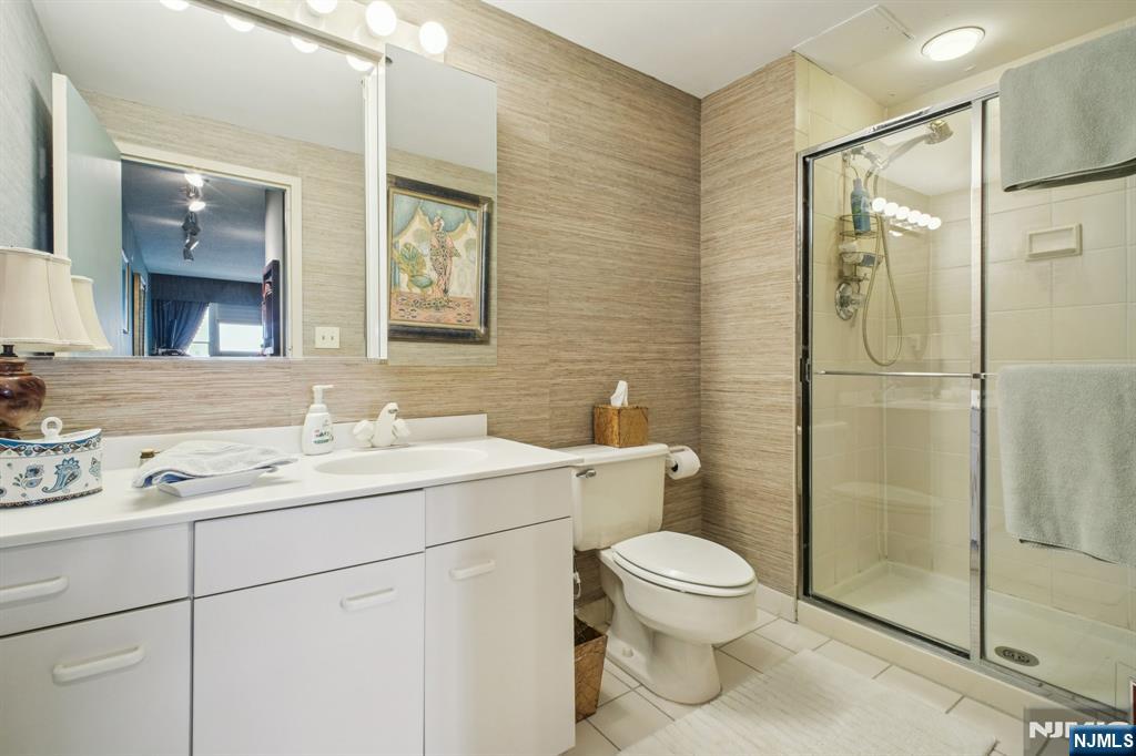 800 Palisade Avenue, Unit PH21A Fort Lee, NJ 07024 - Photo 36 of 50 a bathroom with a toilet sink shower and mirror