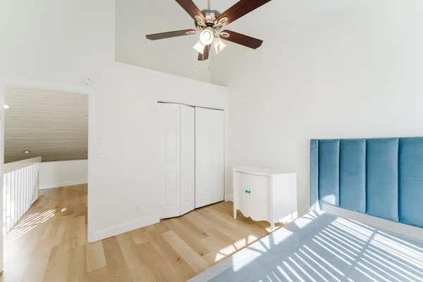a bedroom with a bed and a ceiling fan