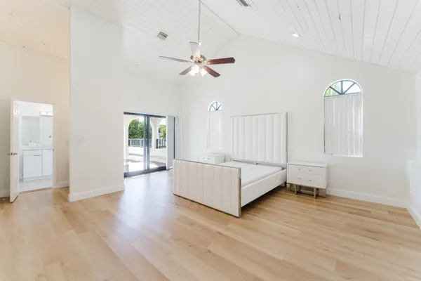 a spacious bedroom with a bed and a chandelier
