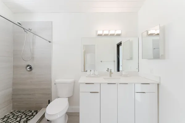 a bathroom with a sink a toilet and shower
