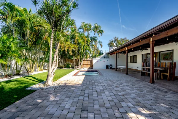 a view of a house with backyard and a tree