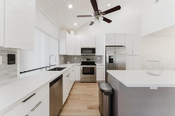 a kitchen with a sink a counter top space stainless steel appliances and cabinets