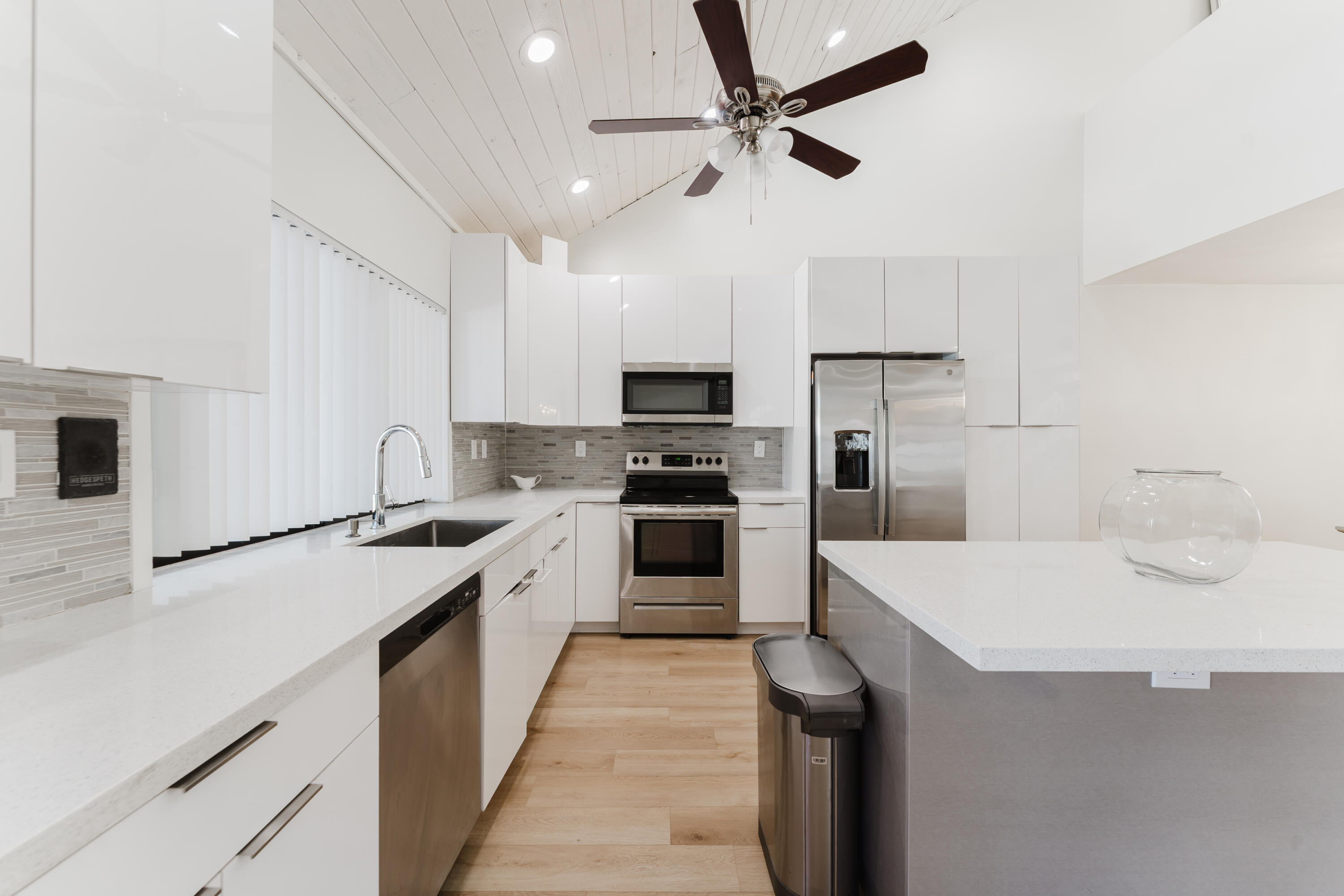 665 Jeffery Street Boca Raton, FL 33487 - Photo 9 of 44 a kitchen with a sink a counter top space stainless steel appliances and cabinets