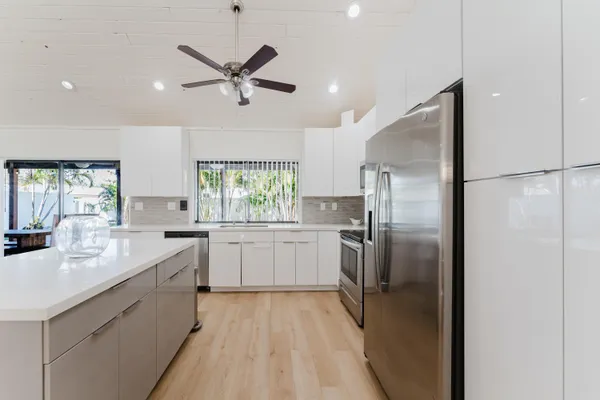 a kitchen with white cabinets and stainless steel appliances