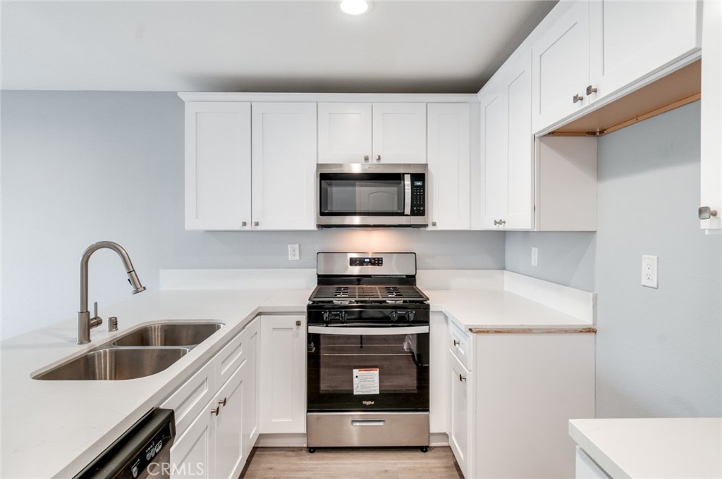 450 East 4th Street, Unit 221 Santa Ana, CA 92701 - Photo 12 of 43 a kitchen with sink a microwave and cabinets