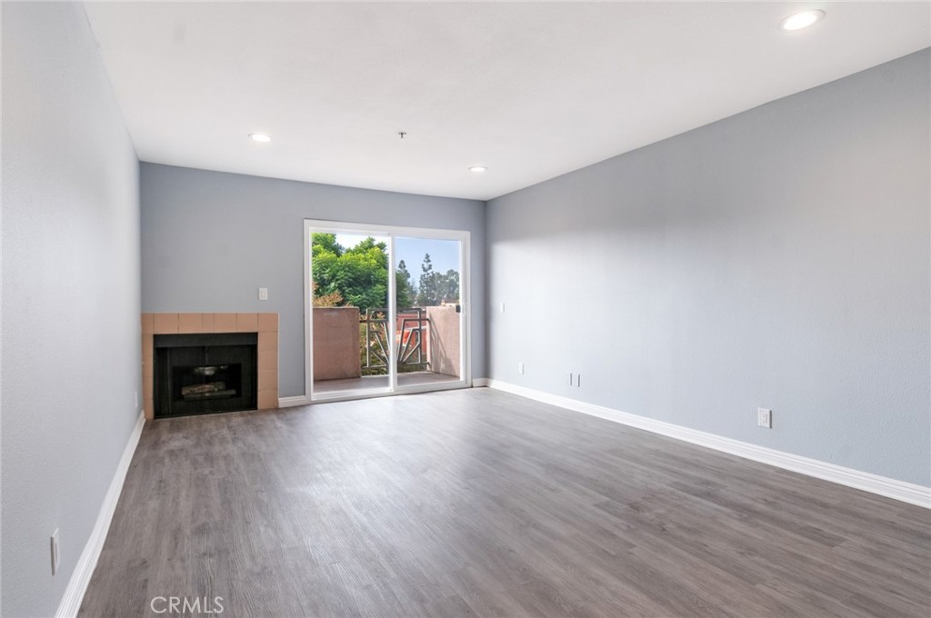 450 East 4th Street, Unit 221 Santa Ana, CA 92701 - Photo 4 of 43 a view of an empty room with wooden floor and a fireplace
