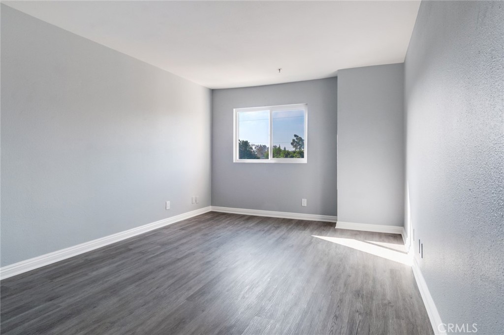 450 East 4th Street, Unit 221 Santa Ana, CA 92701 - Photo 6 of 43 a view of an empty room with wooden floor and a window