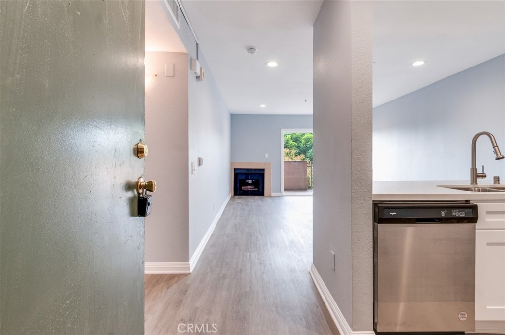 450 East 4th Street, Unit 221 Santa Ana, CA 92701 - Photo 9 of 43 a view of a hallway to a livingroom with wooden floor and staircase