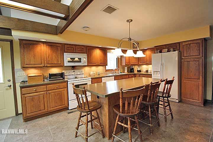 8130 East River Road Ridott, IL 61067 - Photo 8 of 25 a kitchen with stainless steel appliances kitchen island granite countertop a dining table and chairs