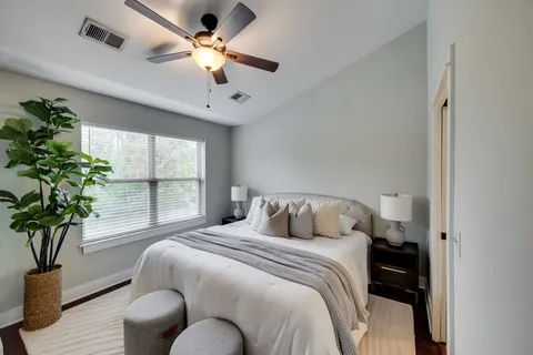 a bedroom with a bed chandelier and a potted plant