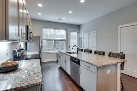 a kitchen with stainless steel appliances granite countertop a sink stove and refrigerator