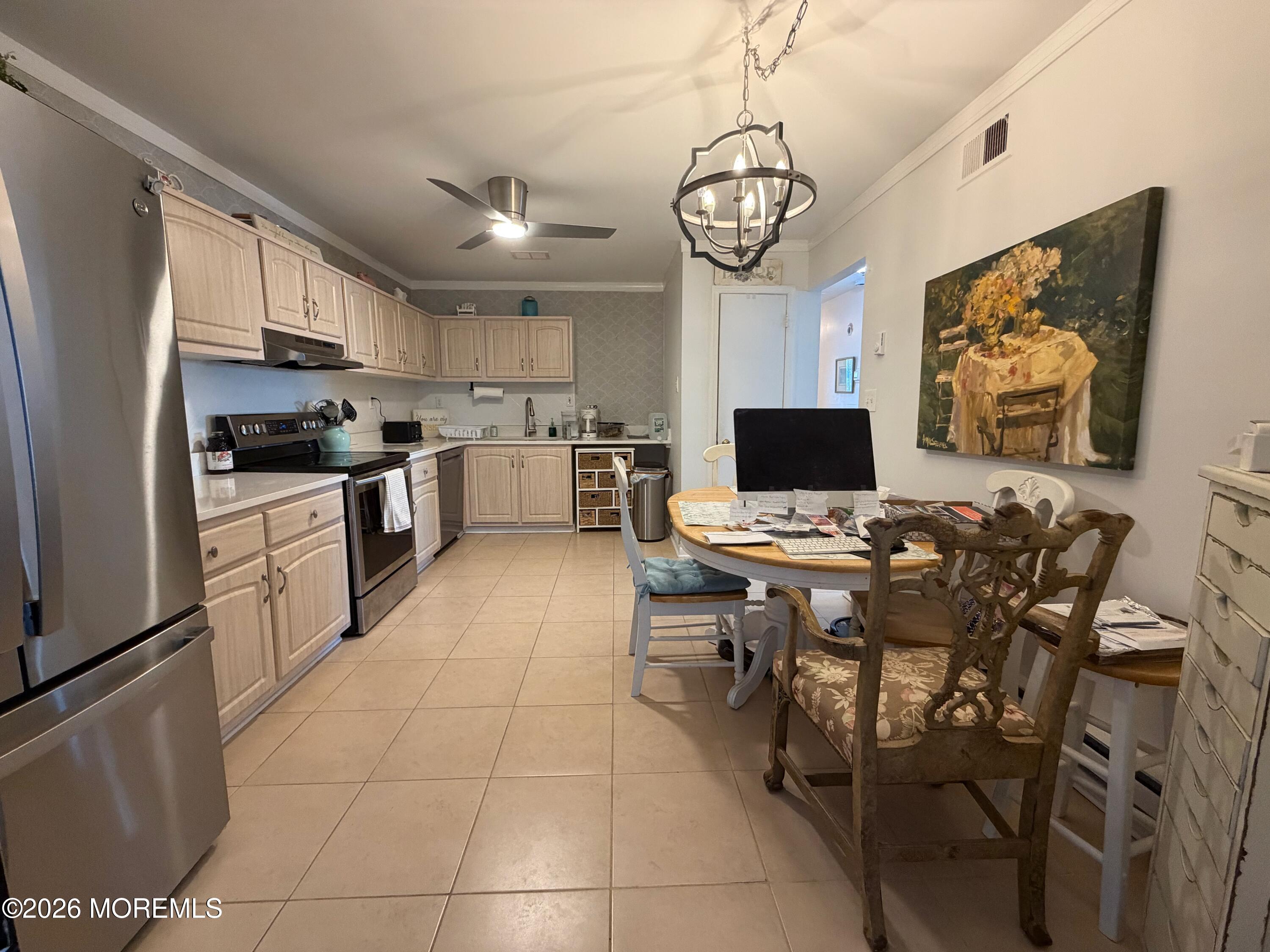 139 Wein Market, Unit F Freehold, NJ 07728 - Photo 8 of 26 a view of a dining room with furniture a kitchen and chandelier