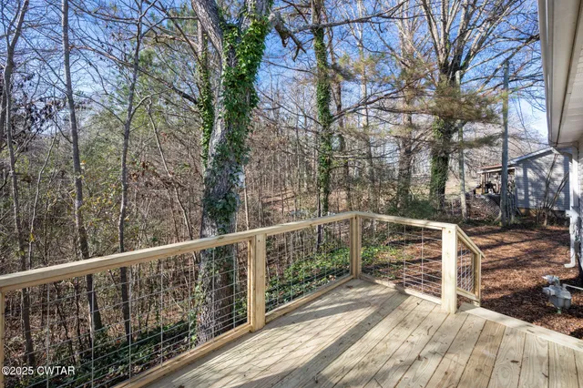 a view of a house with a yard and large tree