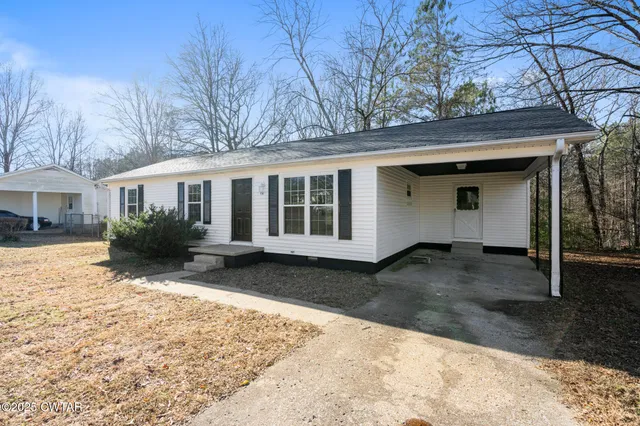 a front view of a house with a yard covered in snow