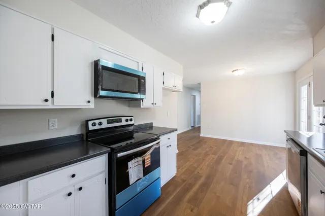 a kitchen with granite countertop a stove and a microwave
