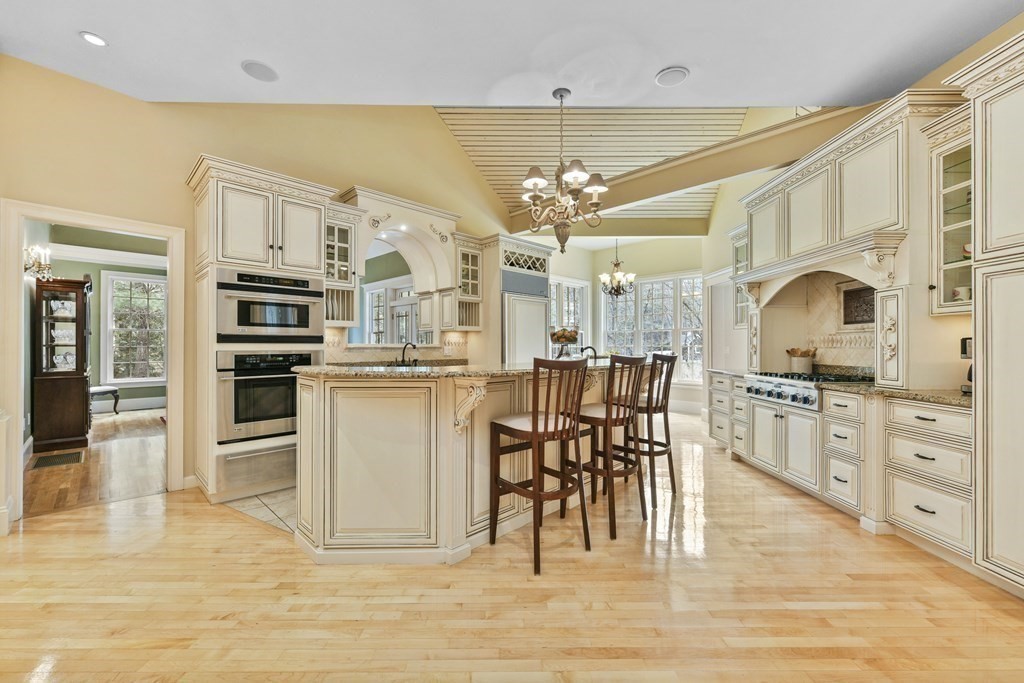 19 Whippoorwill Lane Concord, MA 01742 - Photo 4 of 33 a kitchen with stainless steel appliances kitchen island granite countertop a stove top oven a sink dishwasher a dining table and chairs with wooden floor