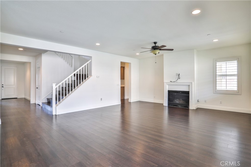 2795 Devonshire Lane Ontario, CA 91762 - Photo 11 of 50 an empty room with wooden floor a ceiling fan and windows