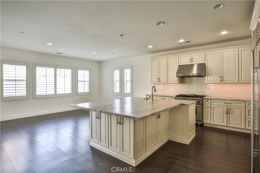 2795 Devonshire Lane Ontario, CA 91762 - Photo 13 of 50 a kitchen with stainless steel appliances granite countertop a sink stove and wooden floor
