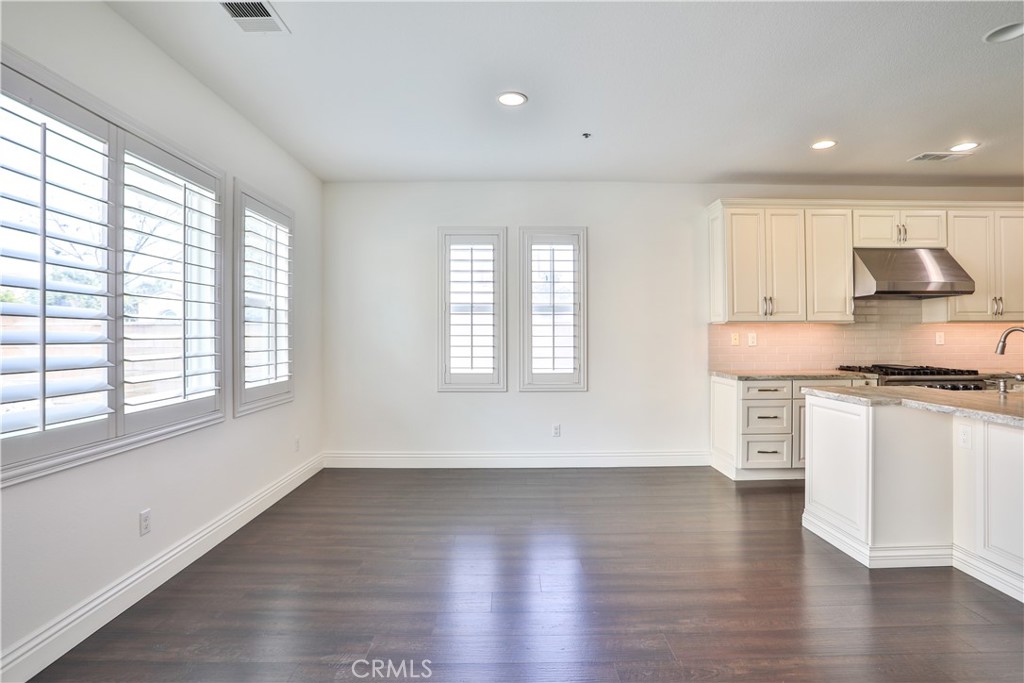2795 Devonshire Lane Ontario, CA 91762 - Photo 24 of 50 a kitchen with stainless steel appliances granite countertop a stove a sink and white cabinets with wooden floor next to windows